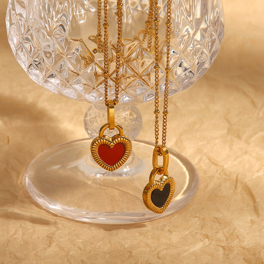 2 necklaces hanging in front of a crystal glass