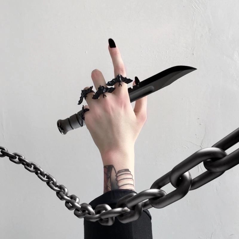 4 Bat rings on fingers, holding a costume Dagger.