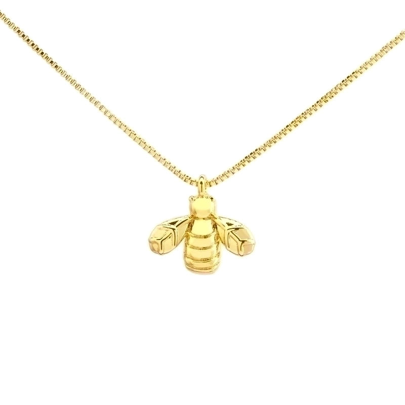 Close up of Gold Bee Pendant on white background