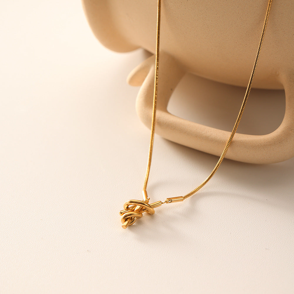 Necklace dangling with pendant resting on surface